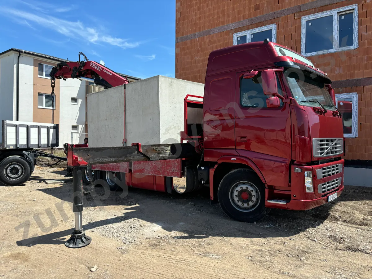 Detail tmavočerveného vozidla Volvo s hydraulickou rukou Fassi a betónovou nádržou